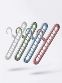 Nine-hole folding hangers in white, green, blue and pink on a plain background